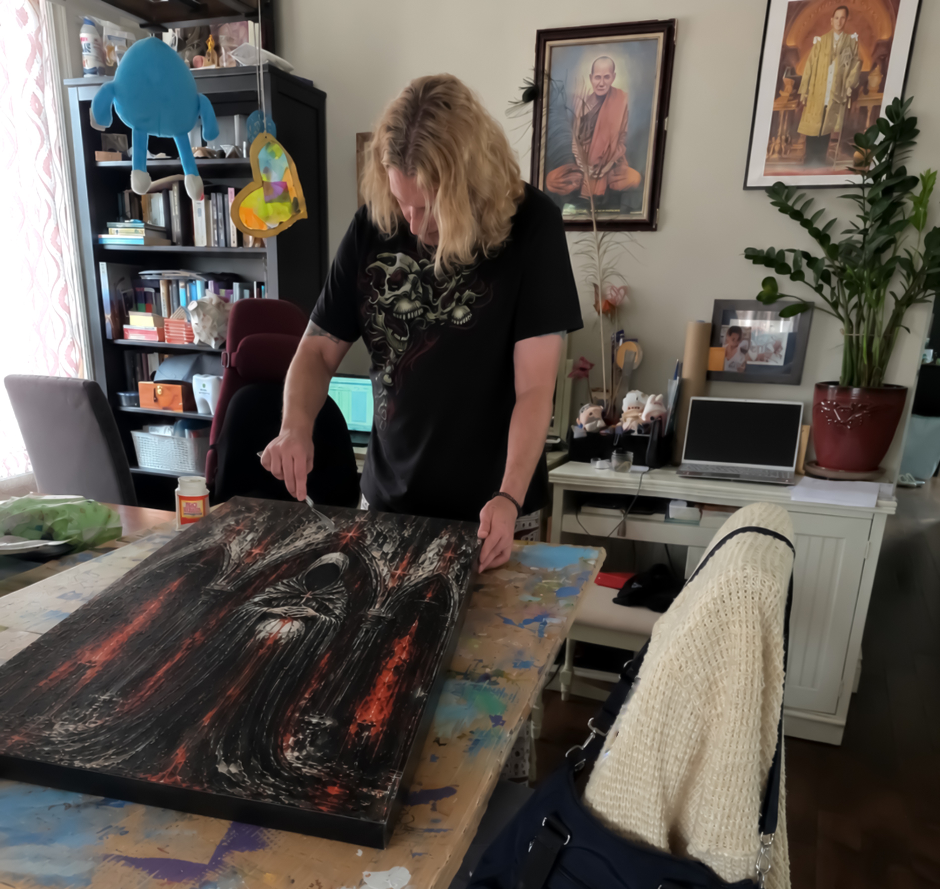 Holding painting in graveyard studio